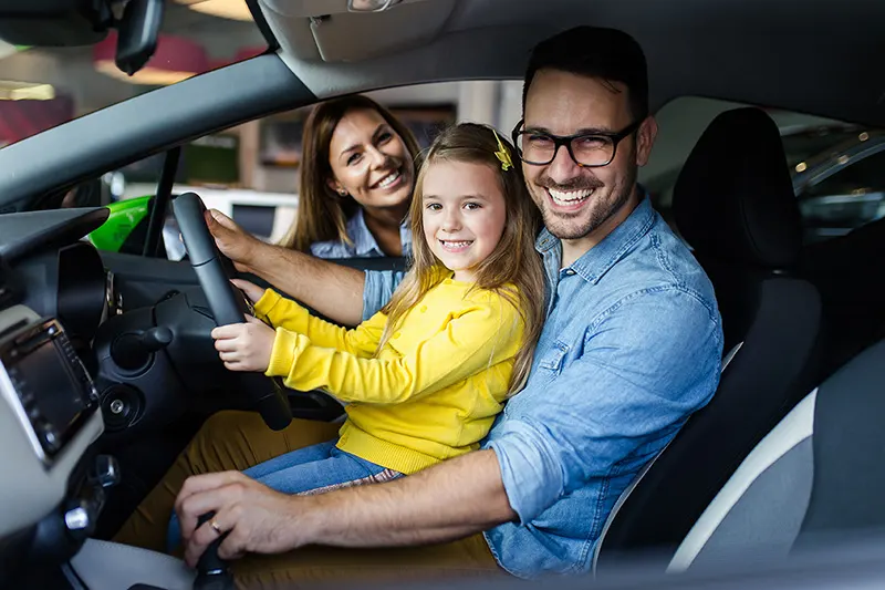 Family of three sitting in car happy with getting specialist car finance